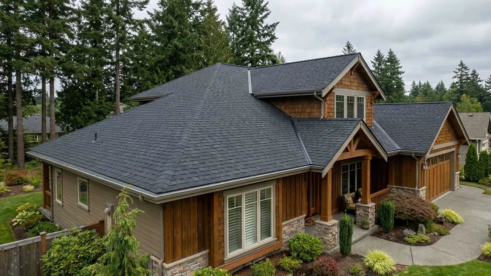 Finished dark architectural asphalt shingle roof on a cedar-sided home