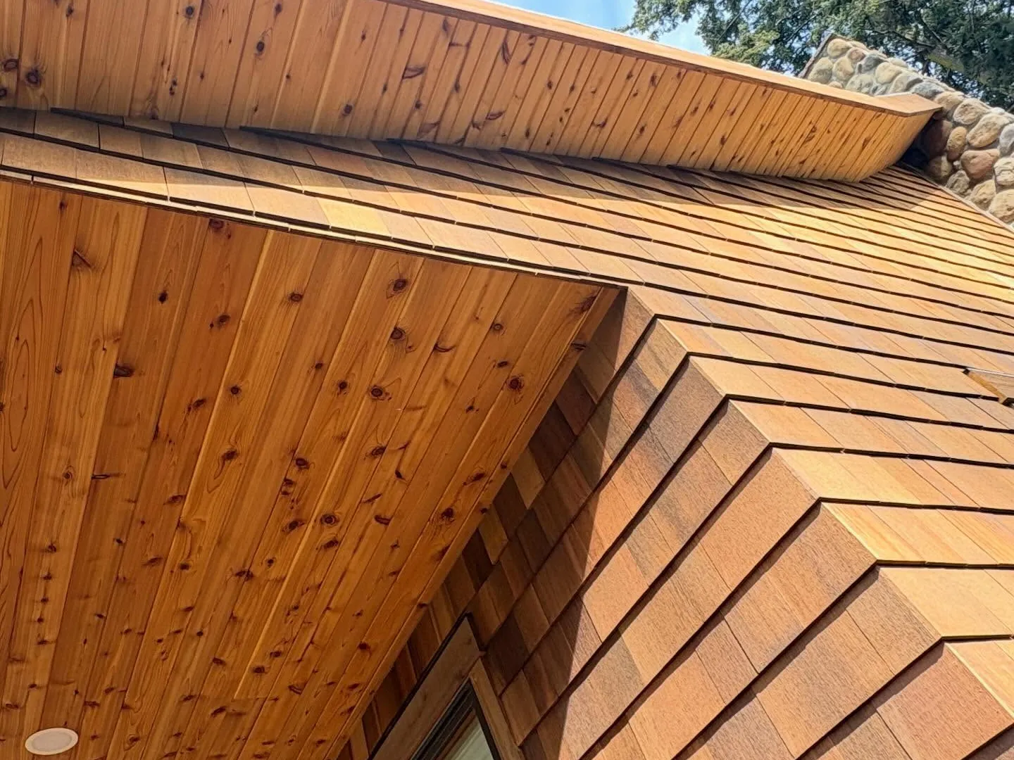 Cedar shingle siding wrapping an outside corner under cedar soffit boards