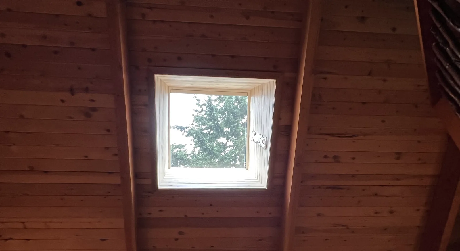New skylight set into a wood-lined vaulted ceiling, seen from inside the home