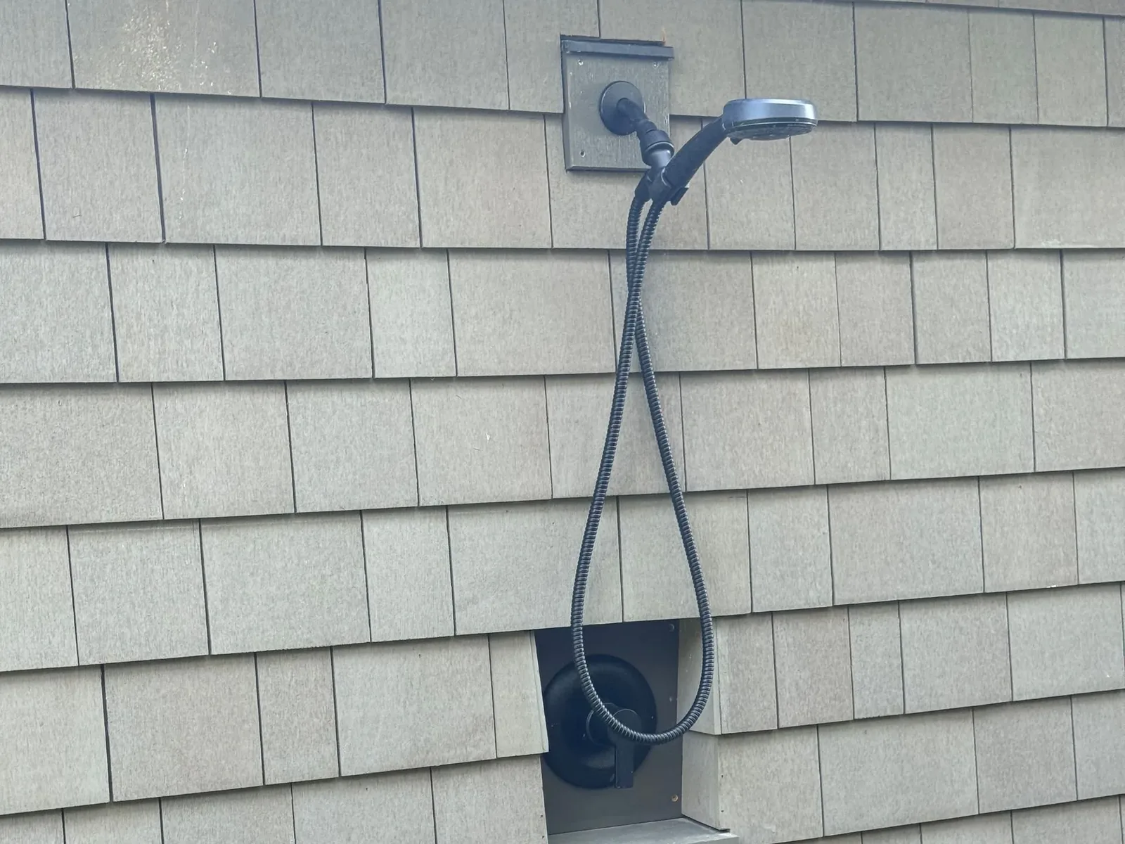 Painted shingle siding with an outdoor shower set into the wall