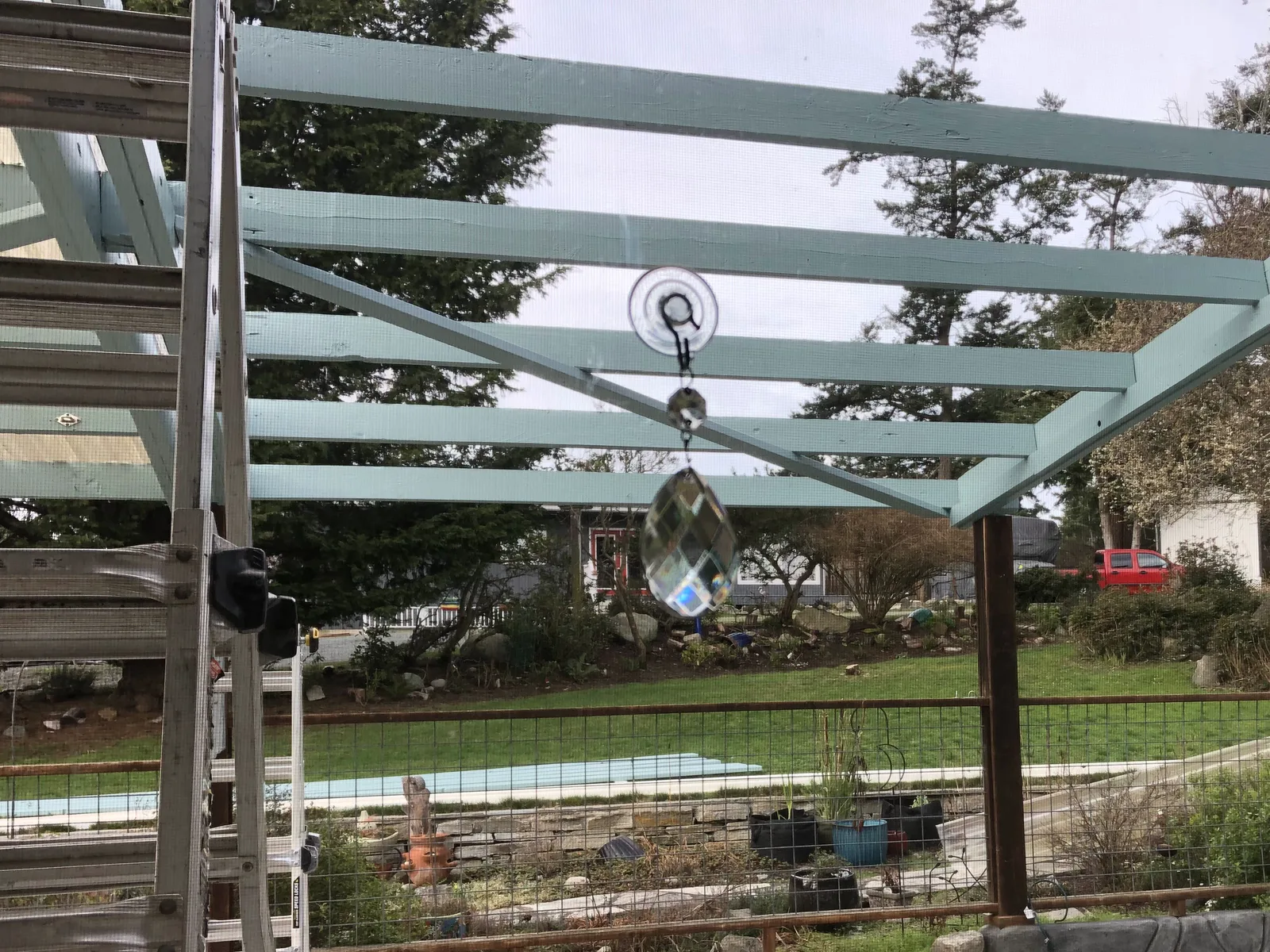 Rebuilt patio cover framing with new painted beams and posts, seen from inside the house