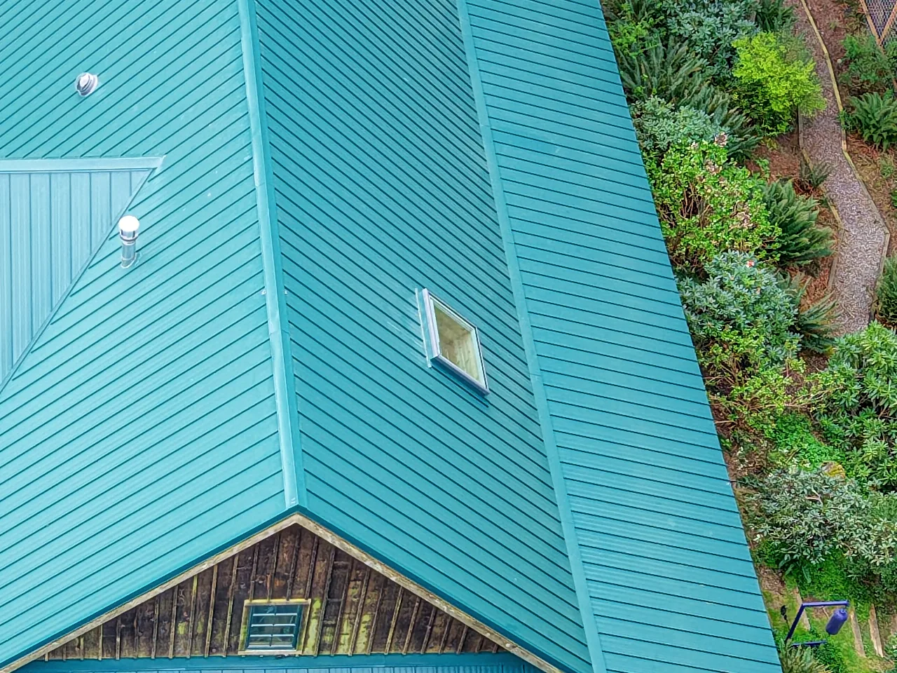 Skylight set into a new green standing-seam metal roof, seen from above